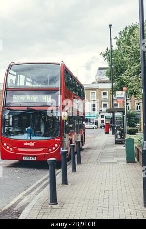 London/UK-30/7/18: red double-decker bus towards Putney Bridge departing the Chippenham Gardens Station on Kilburn Park Road. A bus stop is a designat Stock Photo