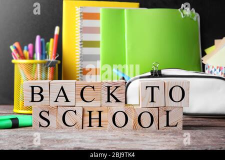 Words BACK TO SCHOOL and stationery set on table Stock Photo