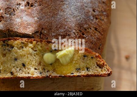 Butter is melting on a slice of fresh, wholemeal, homemade bread Stock Photo
