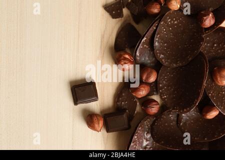 Chocolate chips and hazelnuts on wooden background Stock Photo