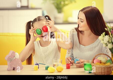 Mother and daughter with Easter eggs having fun at home Stock Photo