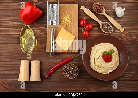 Composition of spaghetti in brown plate on wooden background Stock Photo