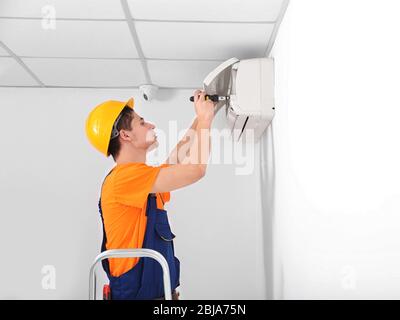 Technician repairing air conditioner on the wall Stock Photo