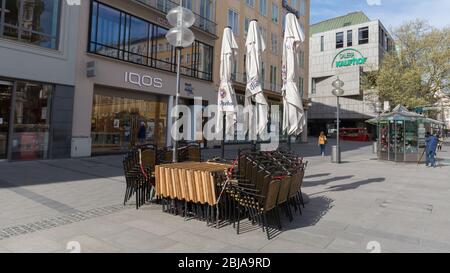 Stacked chairs & folded tables at Marienplatz. Due to Covid-19 all restaurants are closed for guests. Some gastronomy businesses already went bankrupt Stock Photo
