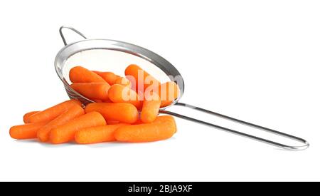 Small baby carrots in sieve on white background Stock Photo