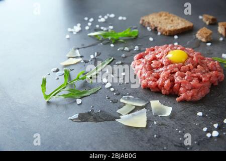 Tartare steak with ingredients on grey background Stock Photo