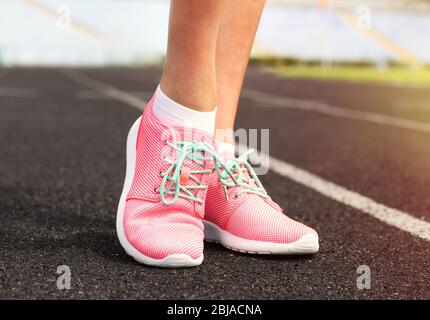 Woman wearing pink sneakers on a running stadium Stock Photo - Alamy
