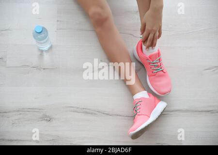 Woman wearing pink sneakers on wooden floor background Stock Photo - Alamy