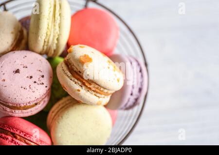 Colorful tasty macaroons in metallic bowl on light background Stock Photo
