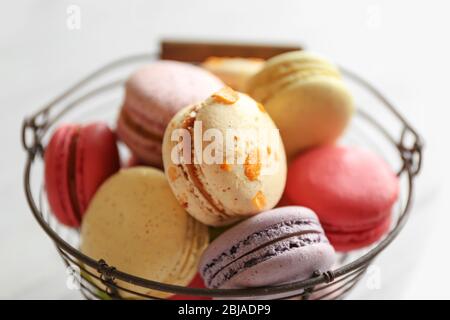 Colorful tasty macaroons in metallic bowl on light background Stock Photo
