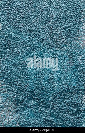 Background texture wall of a house covered with small pebbles fastened with mortar. Painted in blue. Vertical. Stock Photo