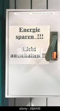 sheet of paper lettering 'save energy, switch of the light' on the switch box for lights, Germany Stock Photo