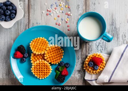 Traditional Belgian waffles with fresh fruit and milk. Flat lay, top view Stock Photo