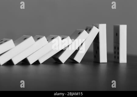 Dominoes falling on gray background Stock Photo