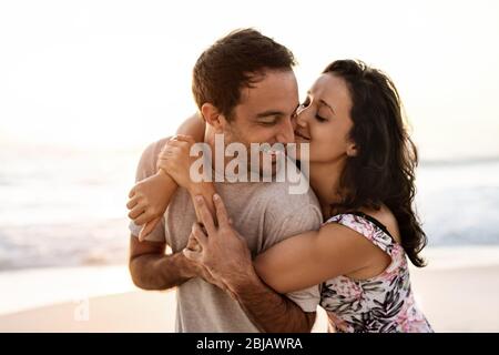 Loving couple having fun at the beach at sunset Stock Photo