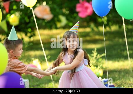 Children celebrating birthday in park Stock Photo