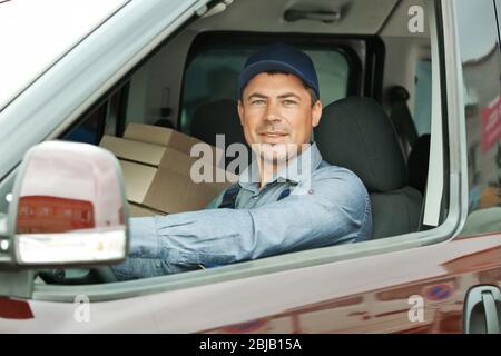 Delivery concept. Postman driving delivery car Stock Photo