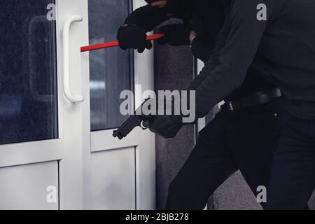 Armed thieves breaking a door Stock Photo