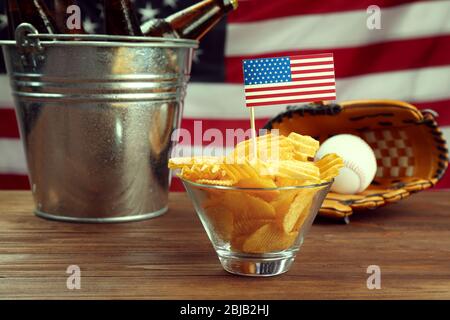 Bowl with chips, baseball glove and ball and beer on wooden table Stock Photo