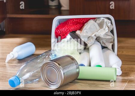 Plastic trash can near the kitchen cabinet - bottles, plastic and metal ...