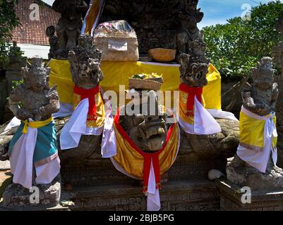 dh Balinese Batuan temple gods BALI INDONESIA Traditional Hindu gate guard dress guards offerings guardians statues offering heritage asian temples Stock Photo