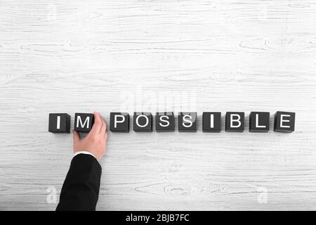 Human hand turning word impossible into possible Stock Photo
