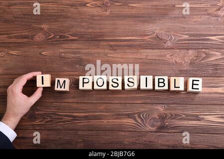 Human hand turning word impossible into possible Stock Photo
