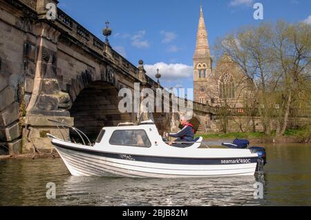 River cruiser passing under the English Bridge over the River Severn in Shrewsbury with Shrewsbury Abbey in the background. Stock Photo