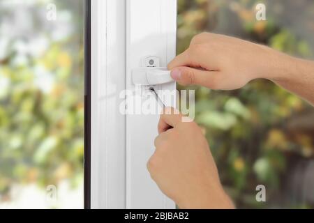 Construction worker repairing window handle Stock Photo