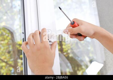 Construction worker repairing window handle Stock Photo