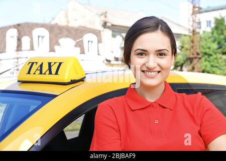 Beautiful female taxi driver standing near car Stock Photo - Alamy