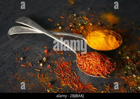 Spices in metal spoons on table Stock Photo
