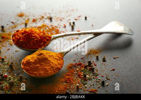 Spices in metal spoons on table Stock Photo