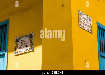 Street sign on colonial facade at the corner of Calle de la Obra Pia and Calle de los Mercaderes, famous streets for shops and hotels. Havana, Cuba. Stock Photo
