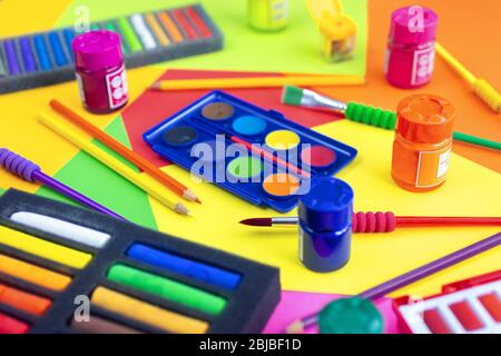 Colorful art workplace, watercolor and crayon pastel chalks on yellow, orange, red, close up Stock Photo