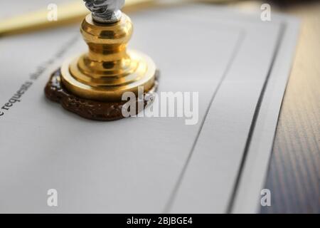 Stamping old notarial wax seal on document Stock Photo