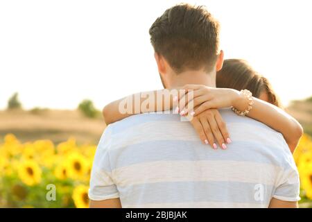 Young man standing back and girl hugging his neck Stock Photo