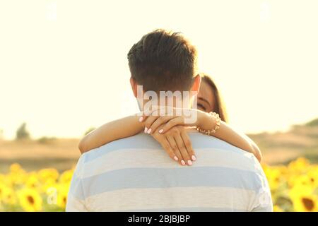 Young man standing back and girl hugging his neck Stock Photo