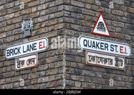 Street signs for Brick Lane and Quaker Street in English and Bengali in East London along with art by Ronzo Stock Photo