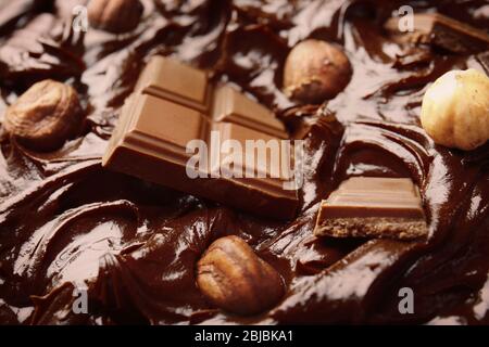 Delicious melted chocolate with pieces and nuts, closeup Stock Photo