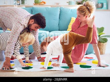 happy family having fun together, playing twister game at home Stock Photo
