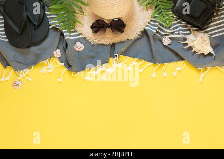 Beach straw sun hat, seashells on yellow background. Summer holiday background. Top view, flat lay. Space for text. Stock Photo