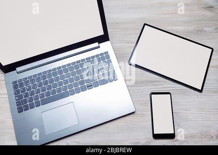 laptop, tablet and phone with blank screen on a wooden table, responsive design concept Stock Photo