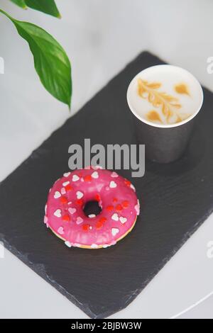 Tray with a donut and coffee on the table. Stock Photo