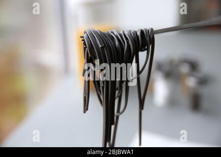 Black pasta on fork in kitchen Stock Photo