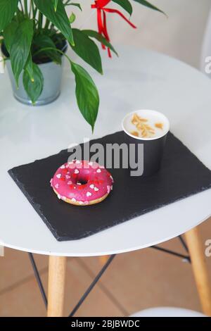 Tray with a donut and coffee on the table. Stock Photo