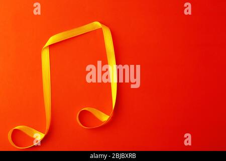 Musical note made of satin ribbon on color background Stock Photo - Alamy