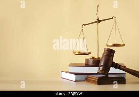 Justice scales, judge's gavel and books on wooden table and beige background Stock Photo