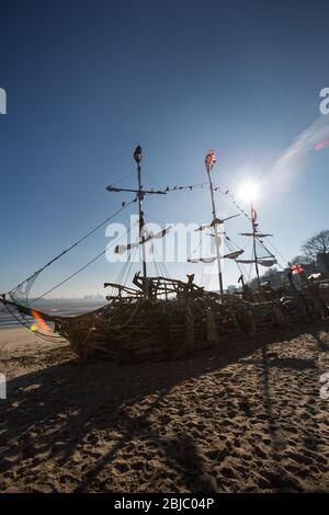 Town of Wallasey, England. Picturesque silhouetted view of the Black Pearl pirate ship on New Brighton beach. Stock Photo