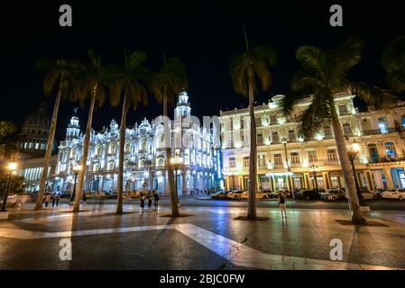 Central park and The Great Theater of Havana at night with passing locals and tourists. The theatre has been home to the Cuban National Ballet, Cuba. Stock Photo